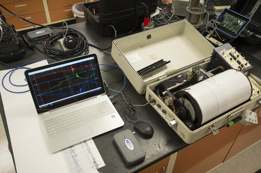Two generations of technology used to record seismic activity, a laptop computer and a drum recorder, are displayed Monday at a laboratory at the U.S. Geological Survey Cascades Volcano Observatory in Vancouver.