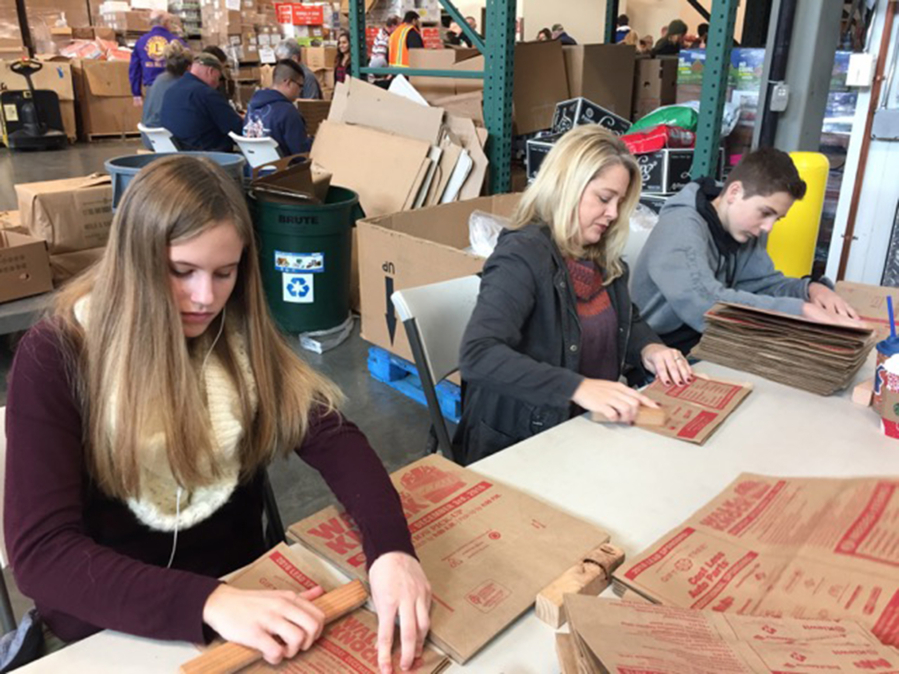 Minnehaha: Emma Dacus, from left, Traci McMurray and Matthew McMurray were some of the 300 volunteers who folded bags Saturday at the Clark County Food Bank in preparation for this year&#039;s Walk &amp; Knock food drive, which will take place Dec.