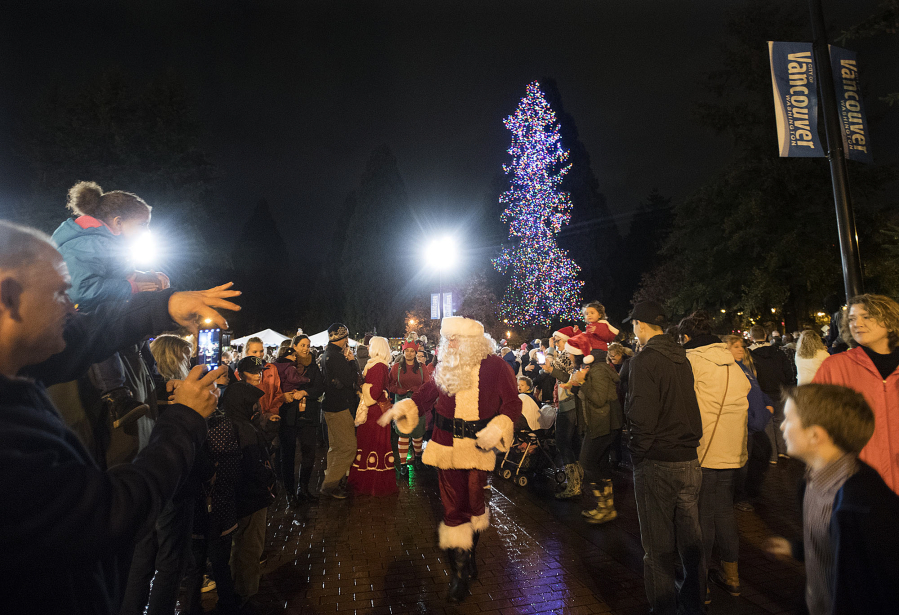 Santa Claus greets a large crowd of spectators after helping to light the tree at Esther Short Park on Friday night.