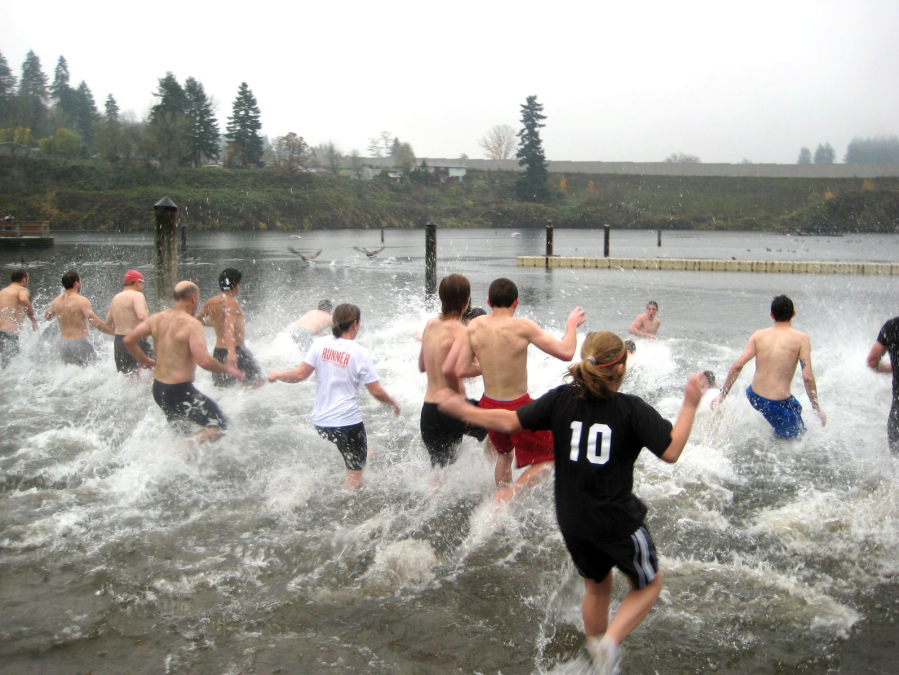 People brave the cold water of Klineline Pond for a polar bear swim during the Turkey Trot.