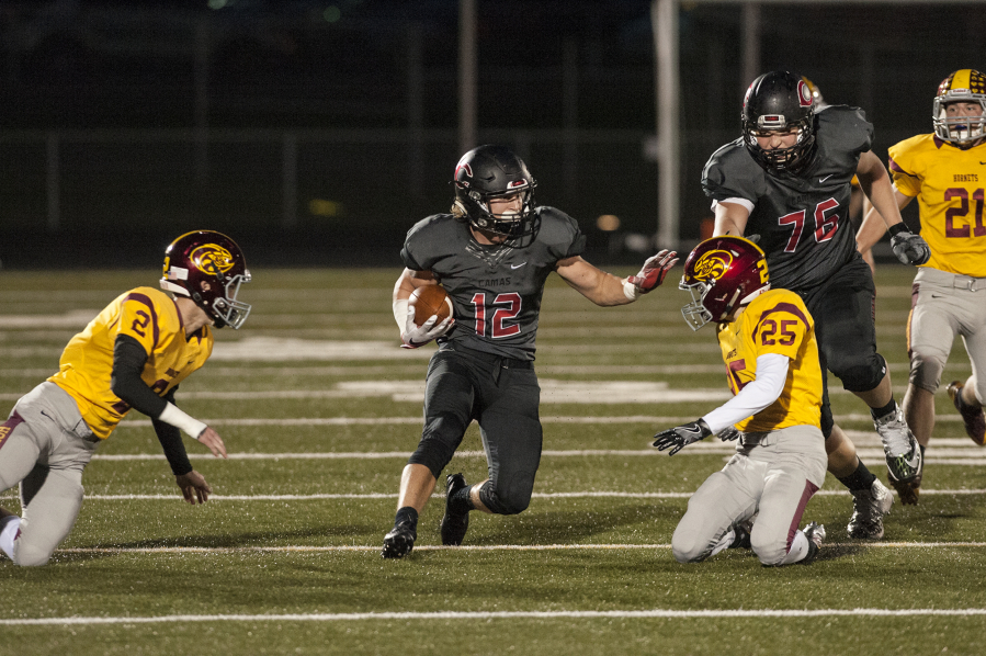 Camas&#039; running back Michael Matthews (12) escapes Enumclaw&#039;s defense during the first quarter. He rushed for 35 yards and one touchdown.
