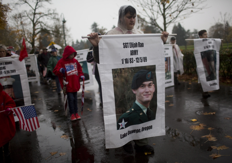 A Boy Scout marching with the Gold Star families on Saturday carries a banner honoring U.S. Army Sgt. Elijah Rao, who was killed in 2009 by a roadside bomb in Afghanistan, during Vancouver&#039;s 30th annual Lough Legacy Veterans Parade at Fort Vancouver.