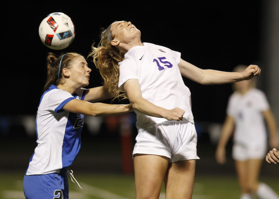 Columbia River's Katie Anthony (15) heads the ball as Olympic's Sydney Troy (left) closes in during girls soccer state tournament first-round game at Kiggins Bowl.