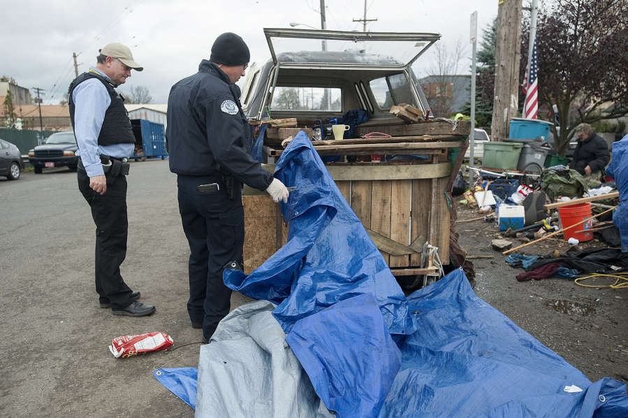 City of Vancouver code enforcement officer Randy Scrivner, left, and Officer Tyler Chavers help clear the area around the Share House on Thursday morning.