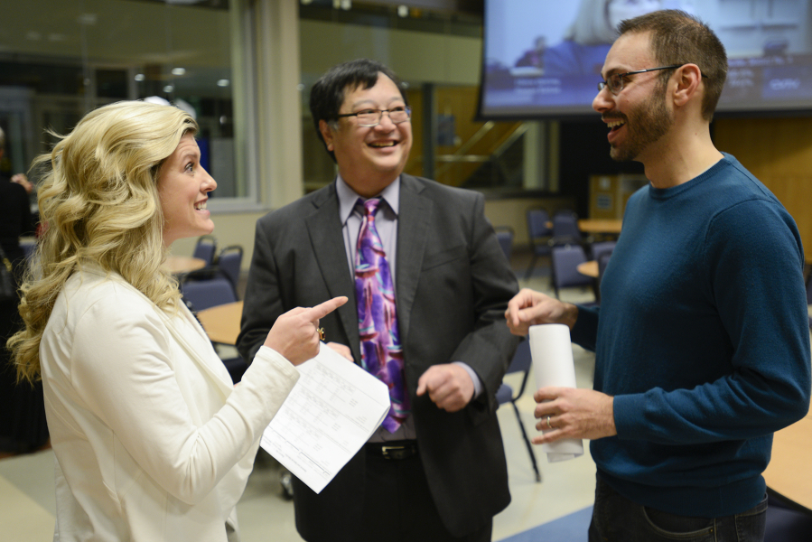 Katie Archer, campaign manager for Bring Vancouver Home, left, speaks to Andy Silver, executive director of the Council for the Homeless, right, and Gary Akizuki, treasurer for Bring Vancouver Home, Tuesday after learning preliminary results of Proposition 1.