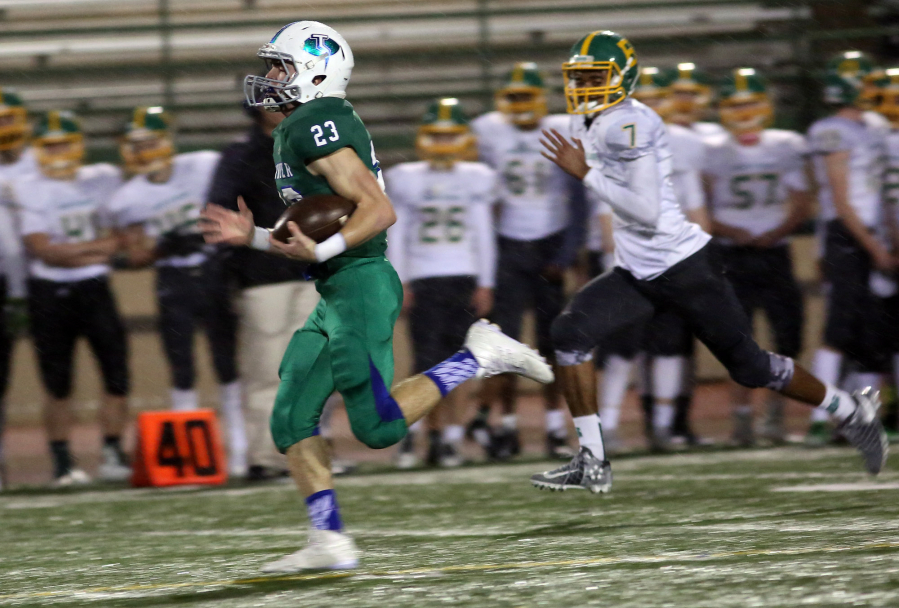 Glen Perry Jr. (23) of Mountain View, runs with the ball as he is pursued by Bishop Blanchet&#039;s Jamiek Satterwhite. Perry had 174 yards rushing and three TDs Saturday.