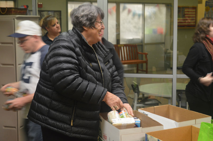 Vancouver Police Activities League volunteer Sandi Glandon assembles a Thanksgiving food bag Tuesday afternoon at the Fruit Valley Community Learning Center in Vancouver.