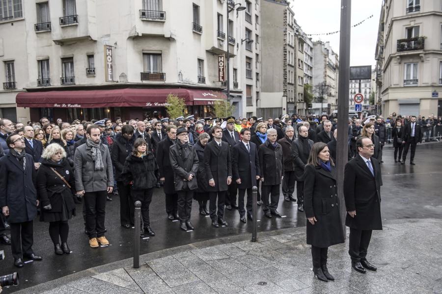 French President Francois Hollande and Paris Mayor Anne Hidalgo stand at attention after unveiling a commemorative plaque near the Petit Cambodge and Carillon cafes in Paris, France, during a ceremony held for the victims of last year&#039;s Paris attacks which targeted the Bataclan concert hall as well as a series of bars and killed 130 people, Sunday, Nov. 13, 2016.