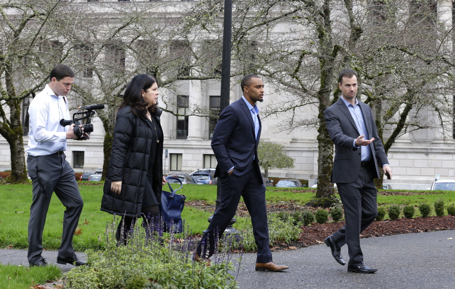 Seattle Seahawks NFL football wide receiver Doug Baldwin, second from right, walks with team personnel before talking to reporters Monday after he testified at a joint legislative task force on the use of deadly force in community policing at the Capitol in Olympia. Baldwin, whose father was a police officer, has been outspoken on the issues of police training, racial profiling, and the use of force by law enforcement officers. (AP Photo/Ted S.