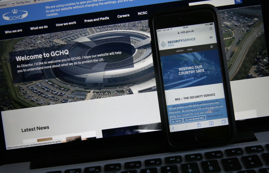 This photo-illustration shows the web flash pages for GCHQ, the British governments communications and electronic surveillance headquarters, and The Security Service (MI5), the governments internal security service, on a computer and smartphone in London, Friday, Nov. 25, 2016. After months of wrangling, Parliament has passed a contentious new snooping law that gives authorities ??? from police and spies to food regulators, fire officials and tax inspectors ??? powers to look at the internet browsing records of everyone in the country.