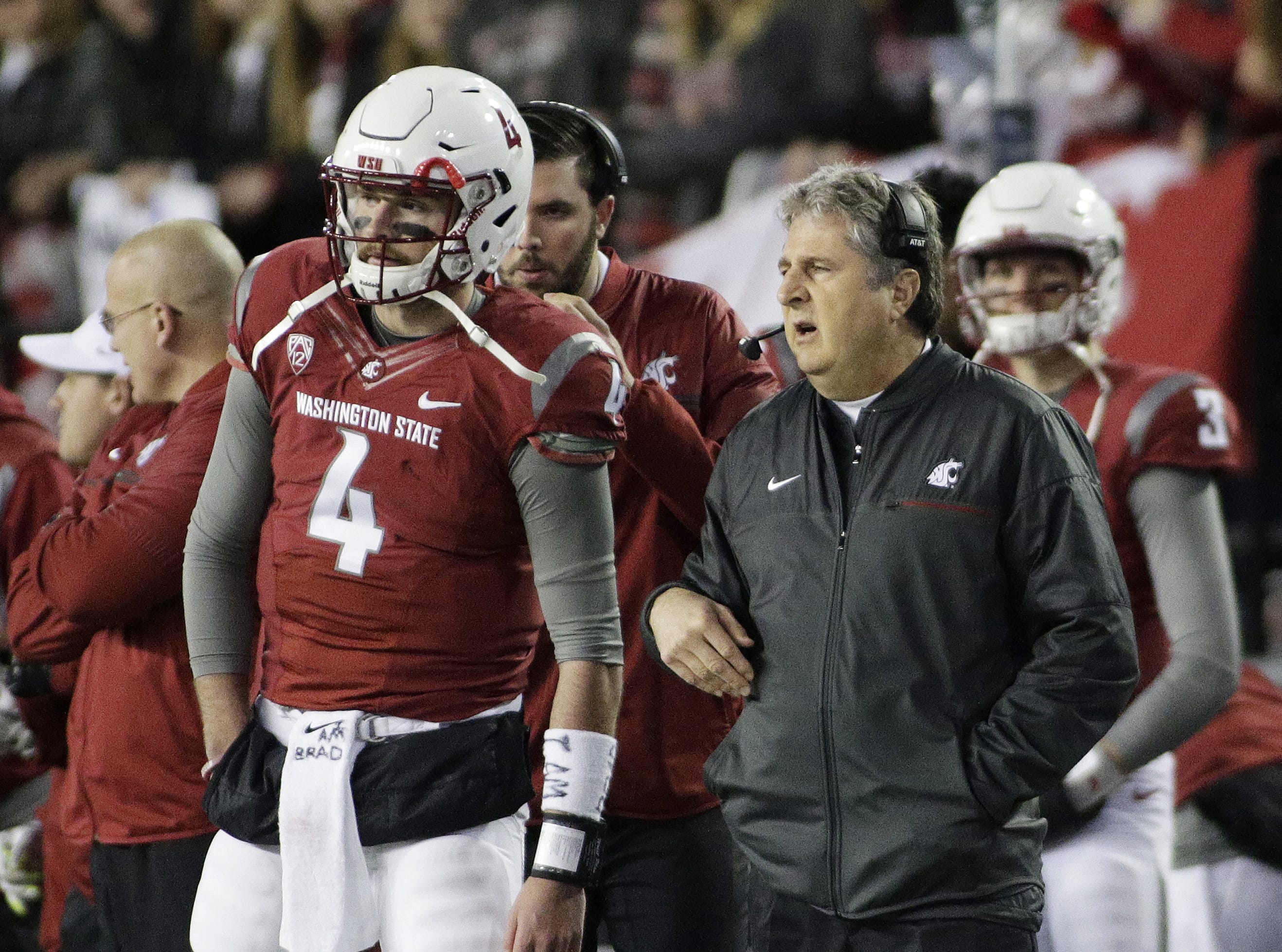 Washington State coach Mike Leach, right, speaks with quarterback Luke Falk (4) during the first half of an NCAA college football game against California in Pullman, Wash., Saturday, Nov. 12, 2016.
