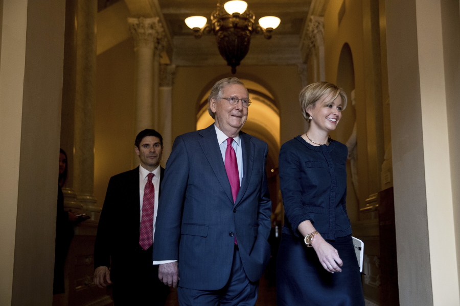 Senate Majority Leader Mitch McConnell of Ky., center, accompanied by his Director of Operations Stefanie Hagar Muchow, right, walks back to his office on Capitol Hill in Washington, Wednesday after a Senate Republican conference leadership election meeting where he was re-elected majority leader for the upcoming 115th Congress.