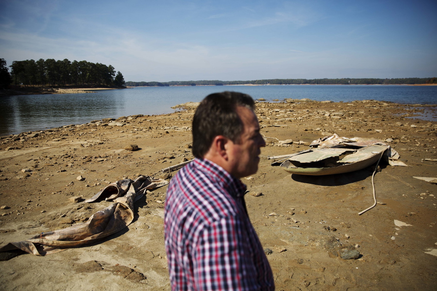 FILE- In this Wednesday, Oct. 26, 2016, file photo, a sunken boat is exposed by receding water levels on Lake Lanier as U.S. Army Corps of Engineers Natural Resources Manager Nick Baggett looks on in Flowery Branch, Ga. Though water shortages have yet to drastically change most people&#039;s lifestyles, southerners are beginning to realize that they&#039;ll need to save their drinking supplies with no end in sight to an eight-month drought. Already, watering lawns and washing cars is restricted in some parts of the South, and more severe water limits loom if long-range forecasts of below-normal rain hold true through the rest of 2016.