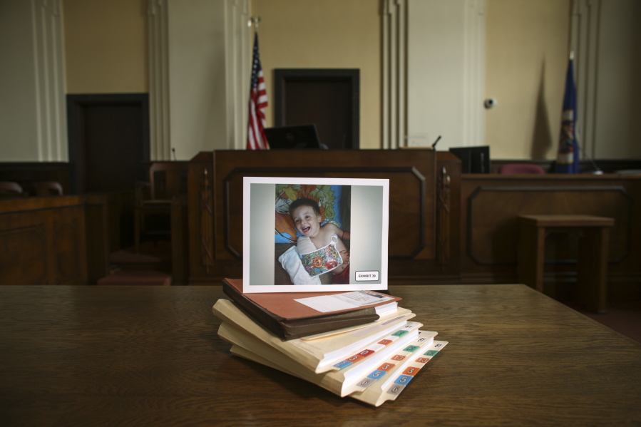 A photograph of Eric Dean, with a broken arm, is placed on folders of exhibits and documents presented in court July 15, 2014, in Glenwood, Minn., relating to the May 2014 trial of Amanda Peltier in the death of her 4-year-old stepson, Eric.