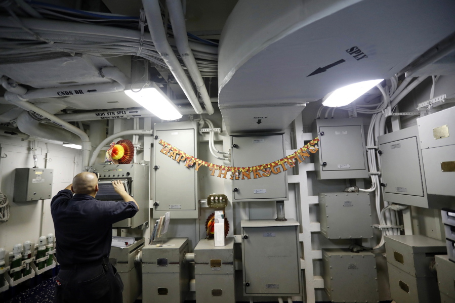 A sailor works near a Thanksgiving banner Monday aboard the USS Dwight D. Eisenhower.