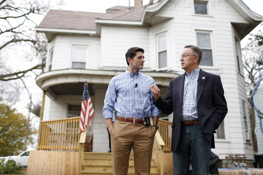 U.S. House Speaker Paul Ryan, left, talks with U.S. Rep. Rod Blum outside a Catholic hospitality house after a tour Wednesday in Waterloo, Iowa.