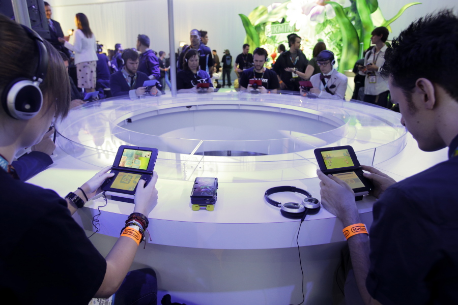 Attendees play video games on the Nintendo 3DS in 2013 at the Nintendo Wii U software showcase during the E3 game show in Los Angeles. Nintendo is ending sales in Japan of its Wii U home console &quot;soon.&quot; (Jae C.
