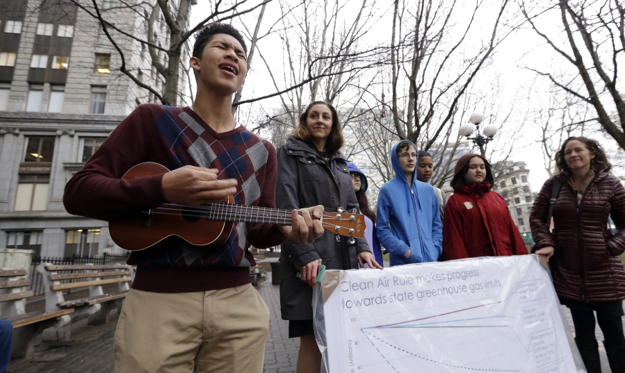 Petitioner Aji Piper, left, starts off a news conference with a song Tuesday in Seattle as he stands with other children asking a court to force state officials to adopt new rules to limit carbon emissions.