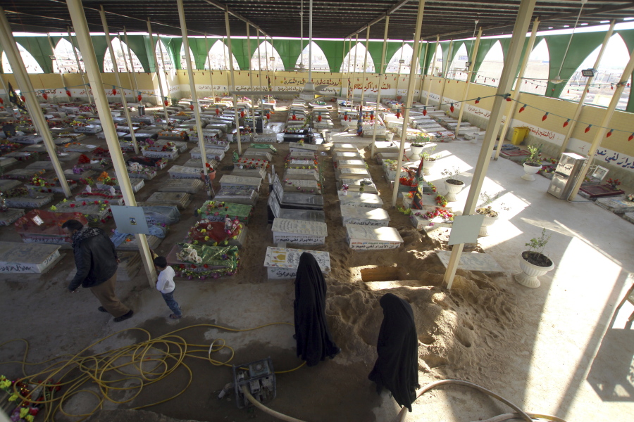 Women pray by the graves of militiamen killed from fighting with Islamic State group militants at the Wadi al-Salam, or &quot;Valley of Peace&quot; cemetery in Najaf, 100 miles (160 kilometers) south of Baghdad, Iraq on Friday.