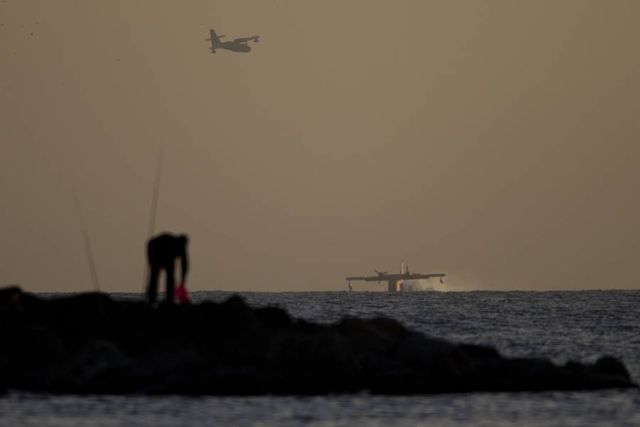 Foreign fire fighting planes load water from the Mediterranean sea off the coast near Netanya, Israel, Saturday, Nov. 26, 2016. More than 40 homes have been burned in a Jewish West Bank settlement and all 1,000-plus of its residents evacuated as firefighters continue battling blazes across the country for a fifth day.