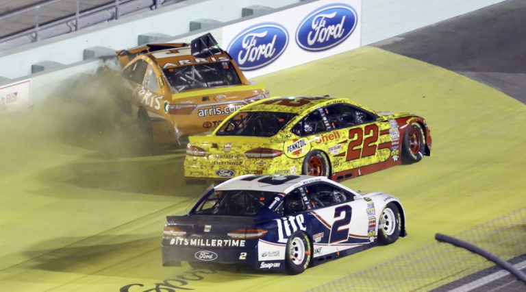 Carl Edwards, top, crashes into the wall as Joey Logano (22) and Brad Keselowski (2) drive by during the NASCAR Sprint Cup auto race Sunday, Nov. 20, 2016, in Homestead, Fla.
