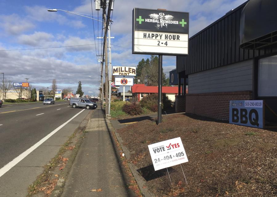 Traffic goes by a sign supporting a marijuana ballot measure in Salem, Ore., in Marion County Wednesday, Nov. 9, 2016. Voters on Tuesday in a county-wide ballot decided to prohibit both retail and medical marijuana businesses in unincorporated parts of the county, putting the future existence of the Herbal Remedies cannabis store in jeopardy.