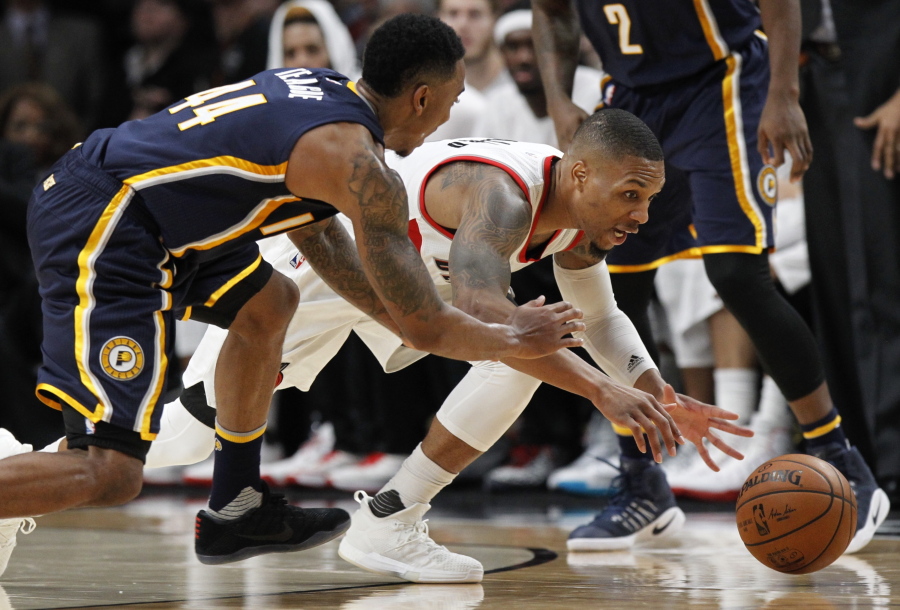 Portland Trail Blazers guard Damian Lillard , right, reaches for a loose ball against Indiana Pacers guard Jeff Teague during the second half of an NBA basketball game in Portland, Ore., Wednesday, Nov. 30, 2016. Portland won 131-109.