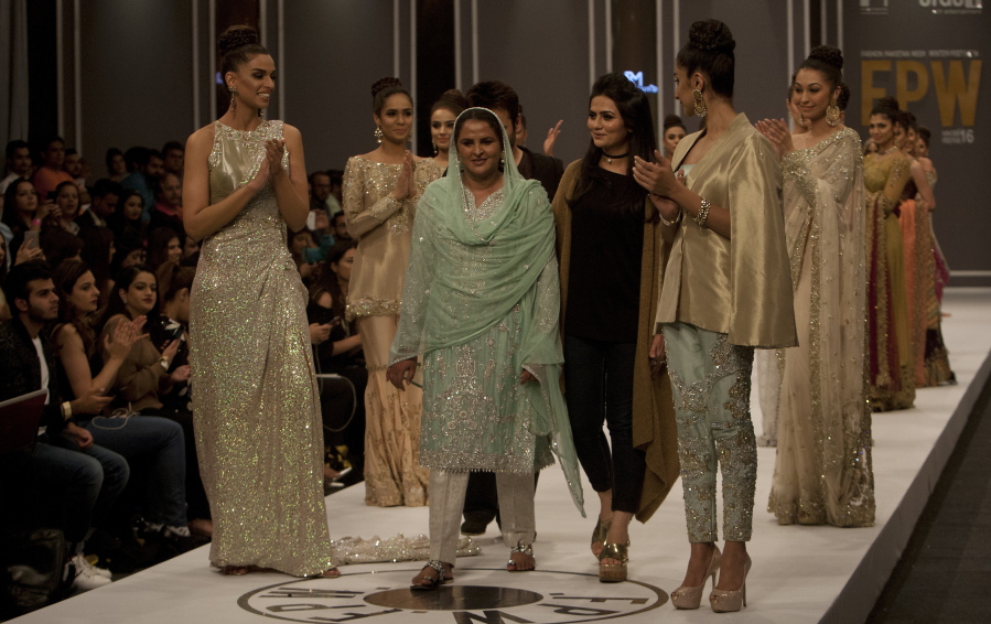 Rape victim Mukhtar Mai, at center in green, walks with models during a fashion show Tuesday in Karachi, Pakistan.