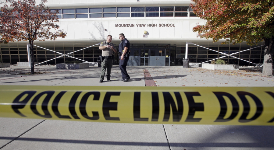 Police stand outside Mountain View High School after several students were stabbed inside the high school Tuesday, Nov. 15, 2016, in Orem, Utah Police say a 16-year-old boy was taken into custody after the stabbings.