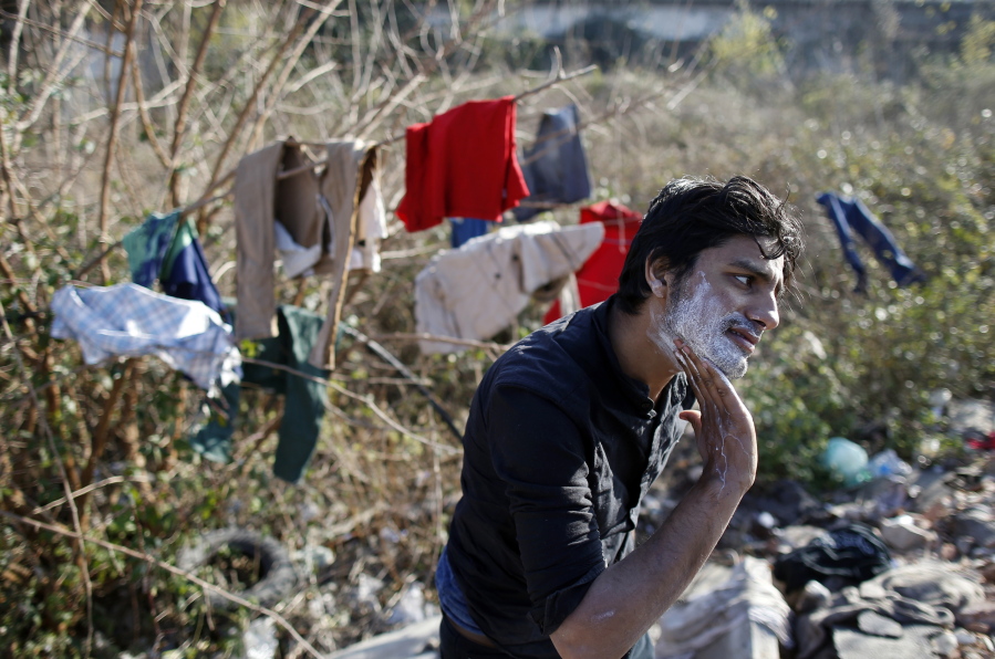 A migrant shaves in front of an abandoned warehouse, in Belgrade, Serbia, Wednesday, Nov. 23, 2016. About 1,000 migrants occupied the rubbish-strewn sprawling complex in search for protection from cold and rain.