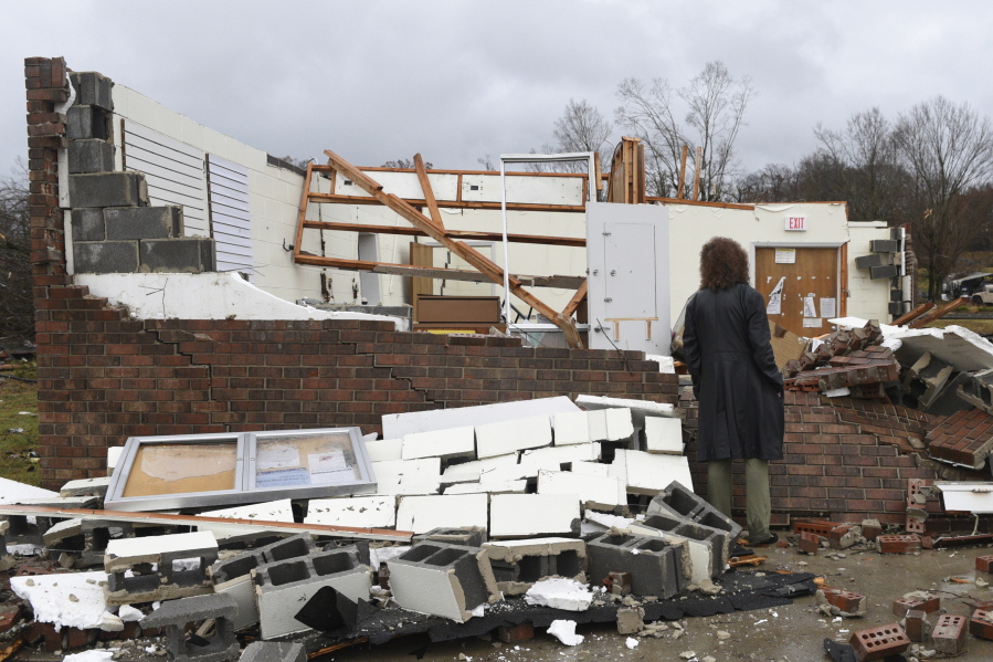 Lydia Nail, who worked at the Ocoee Post Office for 20 years and lives next door, looks at the remains Wednesday in Polk County, Tenn., after a tornado swept through the area early Wednesday. Nail said her home has some leaks from missing shingles, but did not suffer major damage.