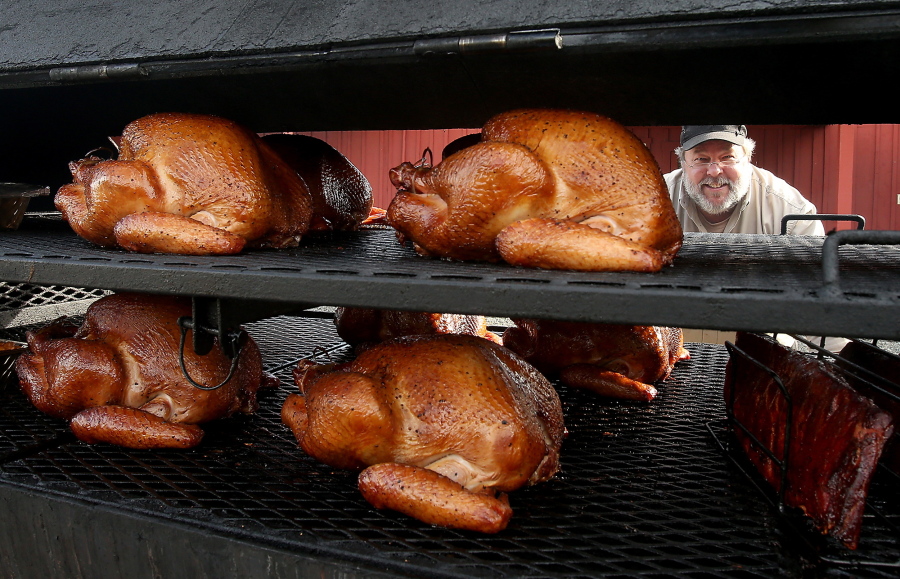 Bubba Idell, of Bubba&#039;s Country Cue, looks through his smoker full of turkeys and ribs at the Farm Kitchen in Poulsbo. Idell moved to Kitsap after immersing himself in the history of BBQ from Texas to the Carolinas. (Photos by Meegan M.