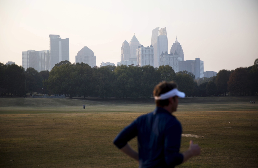 A haze hovers over the midtown skyline from a wildfire burning in the northwest part of the state Monday in Atlanta. Fires, many of them suspected arsons, have prompted evacuations in Georgia, North Carolina and Tennessee in recent days.