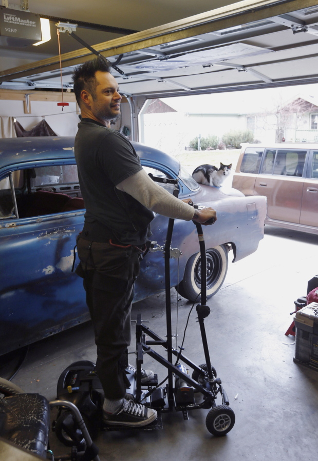Erik Himbert demonstrates his prototype stand-up wheelchair Friday in his garage in Sisters, Ore.