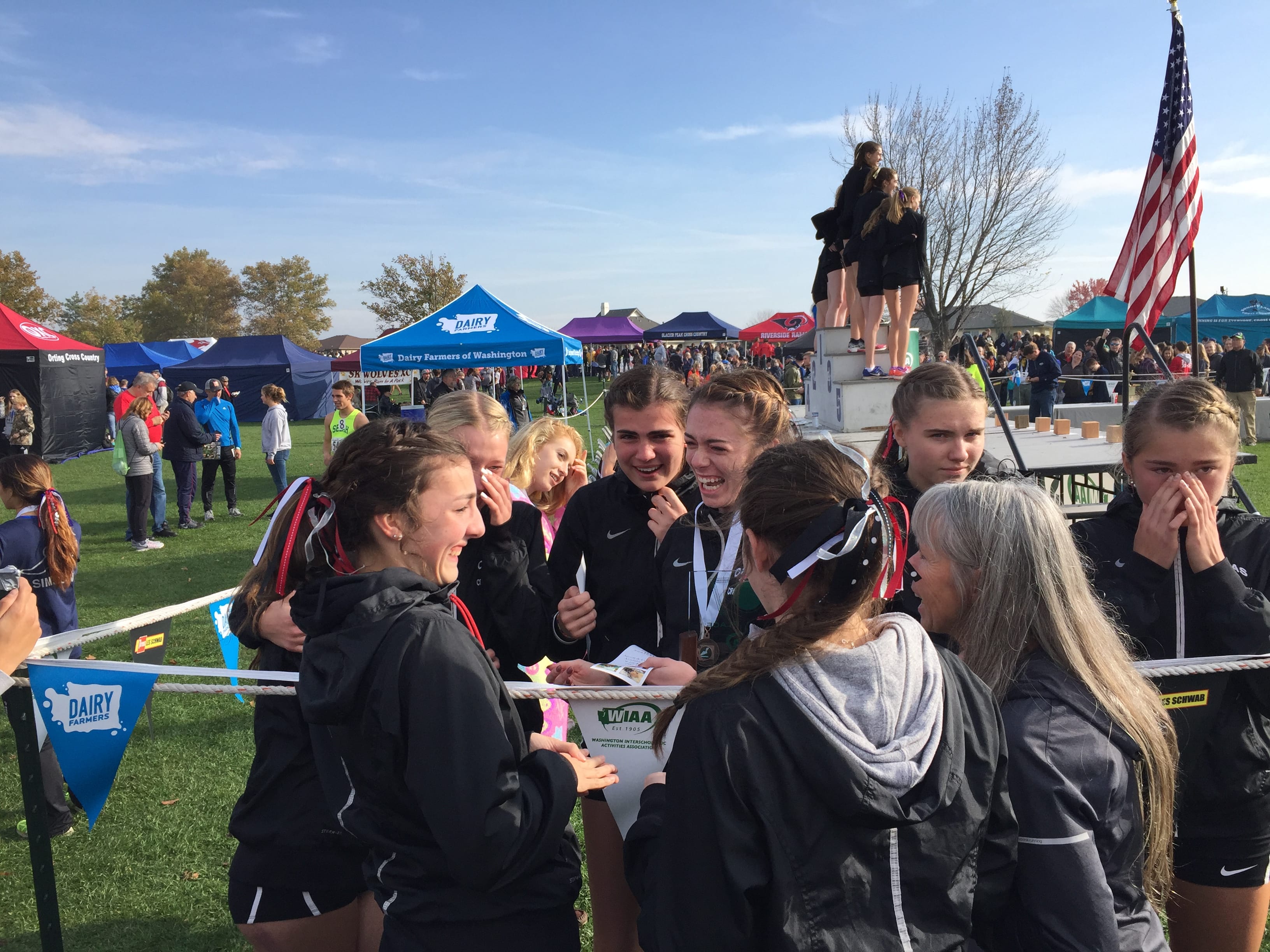 The Camas girls cross country team reacts after learning they qualified for the Nike Borderclash meet via their second-place finish in the Class 4A State Cross Country Championships on Saturday in Pasco.