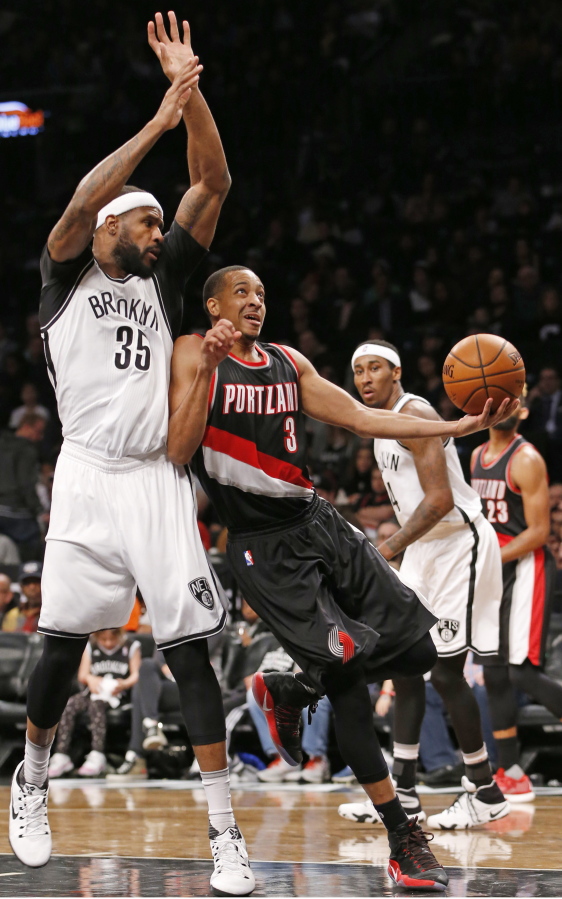 Brooklyn Nets&#039; forward Trevor Booker (35) defends Portland Trail Blazers&#039; guard C.J. McCollum (3) who looks for an opening beneath the Trail Blazers&#039; basket in the first half of an NBA basketball game, Sunday, Nov. 20, 2016, in New York.