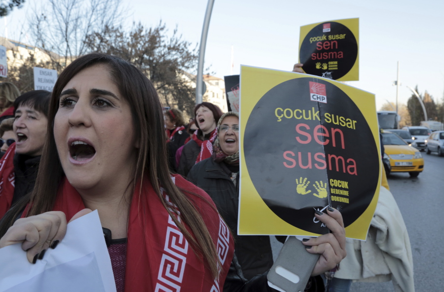 A woman holds a placard as thousands of members of Turkey&#039;s main opposition Republican People&#039;s Party march to the parliament in Ankara, Turkey, on Tuesday. Following a public outcry, Turkey&#039;s government has withdrawn a proposal that critics said would have allowed men accused of sexually abusing underage girls to go free if they were married to their victims.