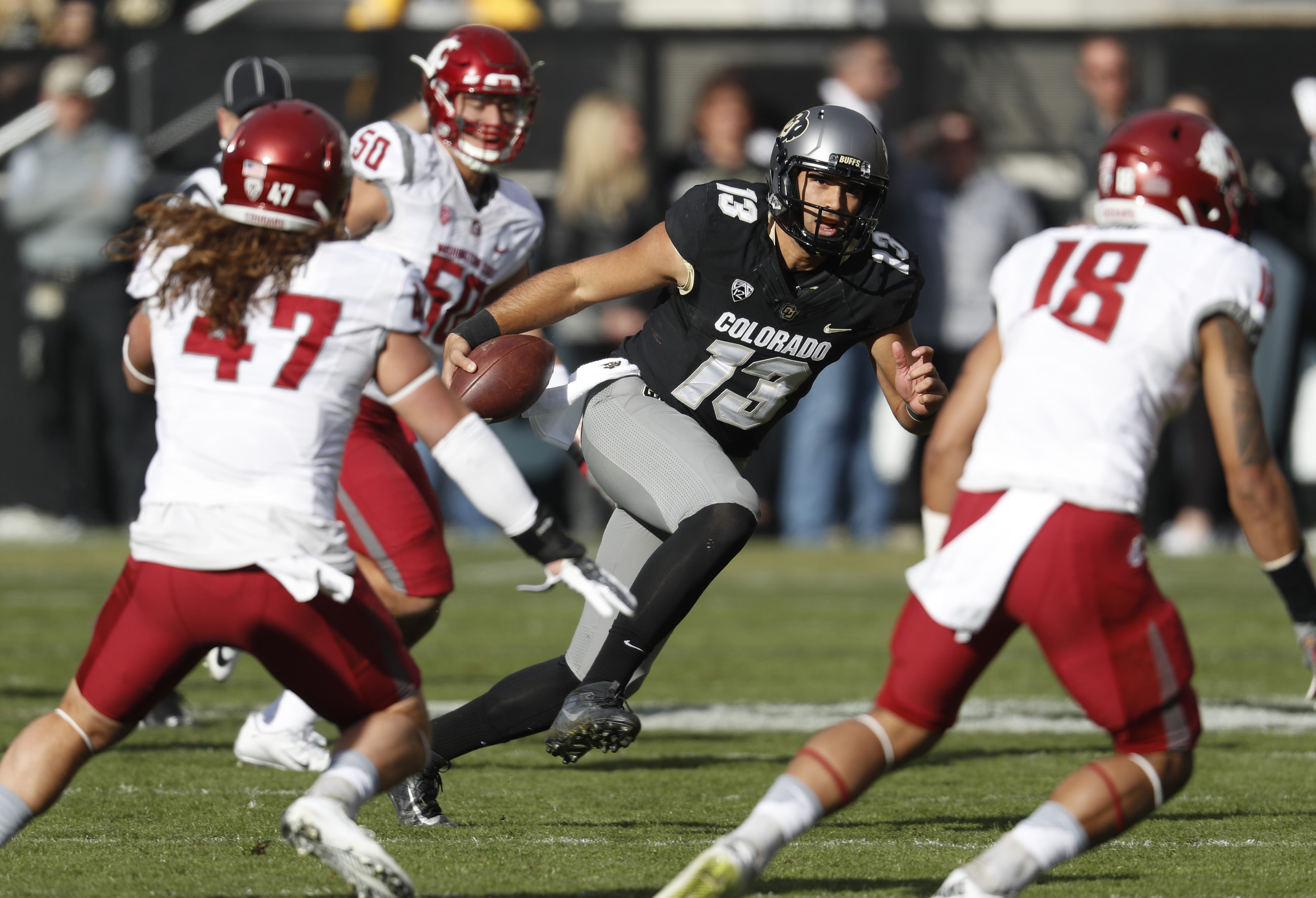 Colorado quarterback Sefo Liufau, center, runs for a short gain as Washington State linebacker Peyton Pelluer, defensive lineman Hercules Mata'afa and safety Shalom Luani close in for a stop in the first half of an NCAA college football game, Saturday, Nov. 19, 2016, in Boulder, Colo.