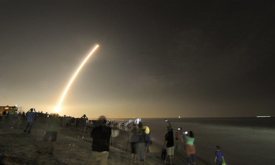 Cell phones light up the beaches of Cape Canaveral and Cocoa Beach, Fla., north of the Cocoa Beach Pier as spectators watch the launch of the NOAA GOES-R weather satellite Saturday. It was launched from Launch Complex 41 at Cape Canaveral Air Force Station on a ULA Atlas V rocket.