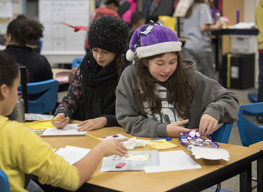 Fifth-graders Kaiah Satcher, left, and Courtney Butler, both 10, decorate letters to adult pen pals paired with them through the RSVP Pen Pal Program run by Volunteer Connections at Burnt Bridge Creek Elementary School on Tuesday morning. The program is looking for adult volunteers to write letters so it can add more students and schools.