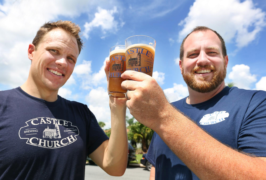 Jared Witt, left, and Aaron Schmalzle, co-founders of Castle Church Brewing Community, hoist some micro-brewed beers outside Schmalzle&#039;s Kissimmee, Fla. home. They plan to open a brew pub in downtown Orlando in coalition with their Lutheran faith. (Stephen M.