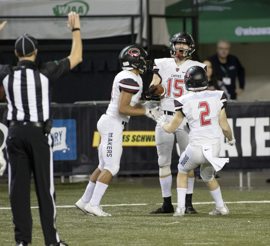 Camas&#039; Cooper McNatt, middle right, celebrates his touchdown catch with teammates Drake Owen, left, and Ryan Rushall, right, during action against Richland in the 4A State Football Championship game Saturday, Dec. 3, 2016,  in Tacoma, Wash.