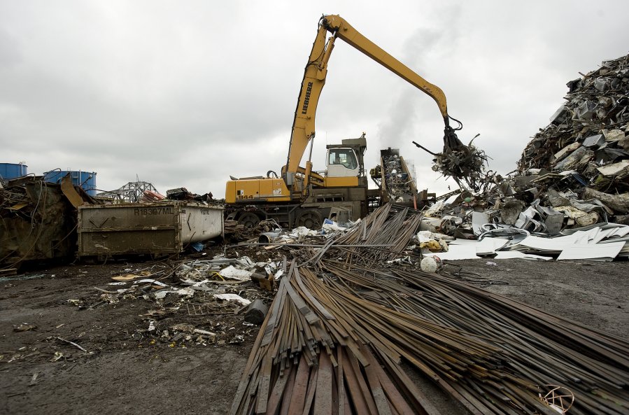 Scrap metal is loaded onto a conveyor and into a shredder at Pacific Coast Shredding.