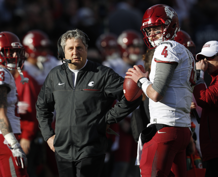 Washington State head coach Mike Leach, left, confers with quarterback Luke Falk during an injury time out against Colorado in the first half of an NCAA college football game, Saturday, Nov. 19, 2016, in Boulder, Colo.