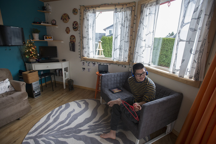 Yung Ting Engelbrecht enjoys a show on his tablet while relaxing at his east Vancouver home, an accessory dwelling unit that’s attached to his parents’ house.