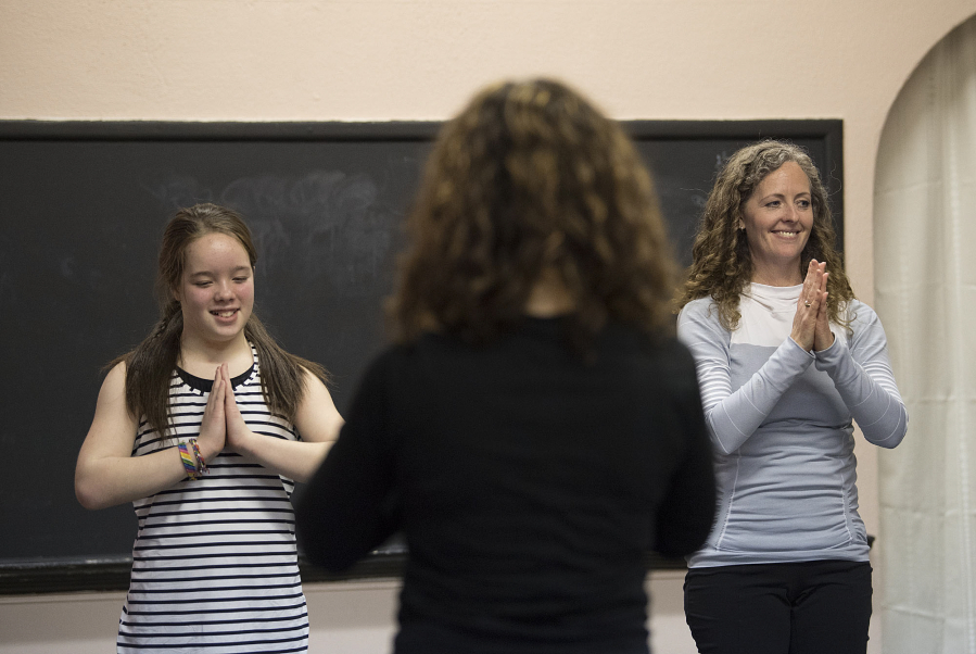 Aderyn McLean, left, teaches yoga alongside her mom, Kelly McLean, at the Vancouver Elite Gymnastics Academy in Camas. The 11-year-old taught classmates at recess to earn certification from Portland-based school Yoga Calm.