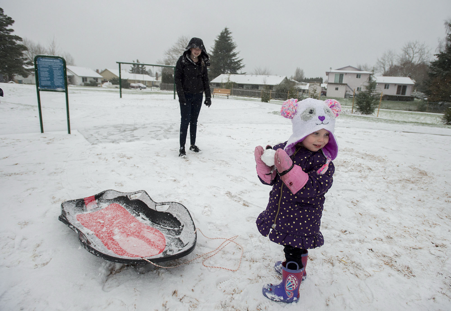 Jasmine Short, 2, of Vancouver joins her 13-year-old sister, Destinee, as they enjoy a snow day at Sorenson Park on Thursday afternoon.