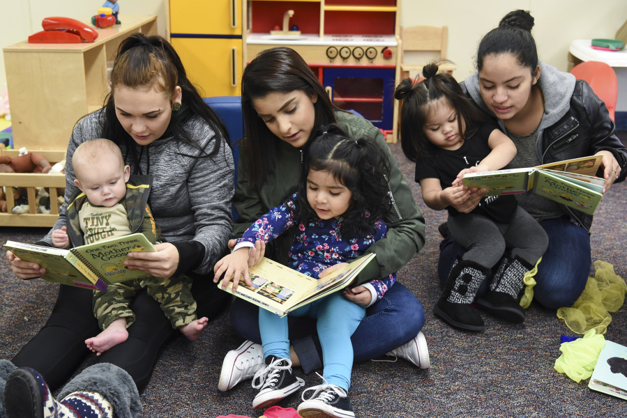 From left to right, Stephanie Watson and her son, Zaine Post; Vanessa Toscano and her daughter, Jaylah Castro; and Fanny Lopez and her daughter, Alexandra Lopez, read together Dec. 13 during story time in the GRADS program at Evergreen High School. A recent state study found that for every dollar invested in the program, students benefit by three times as much.