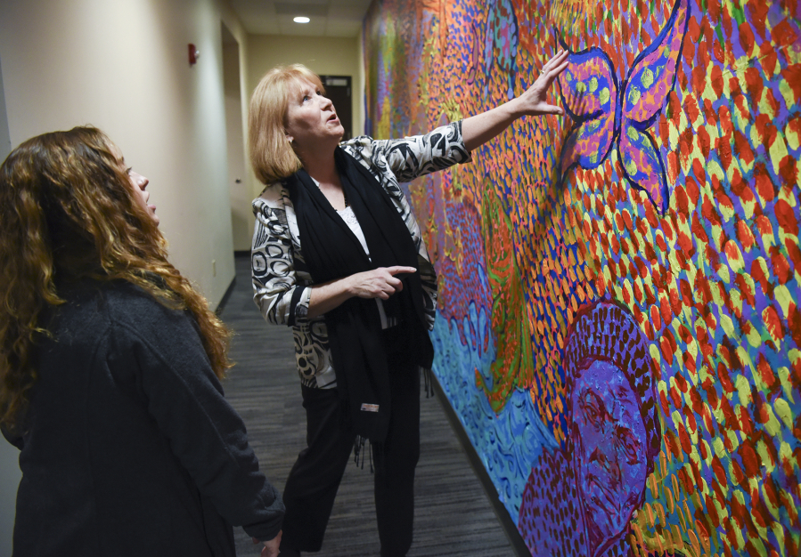 Vancouver?s Mayor Pro Tem, Anne McEnerny-Ogle, center, converses about a student painted mural with Ashley Pirrone, an advisor for the student group MEChA at Fort Vancouver High School, at the Vancouver Police West Precinct, Friday December 2, 2016. Students in MEChA at Fort Vancouver High School spent around 30 hours painting the mural that represents themes such as identity, cultural pride and social justice.
