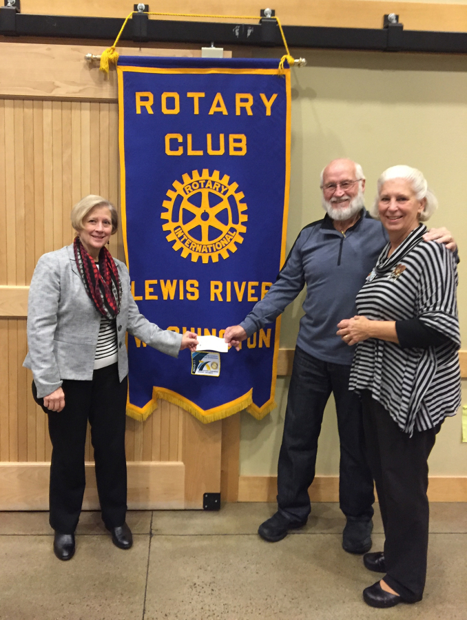 Battle Ground: North County Food Bank&#039;s Jill Kurtz, from left, and John Idsinga accept a check for more than $8,000 from Lewis River Rotary President Kathleen Hensch-Fleming.
